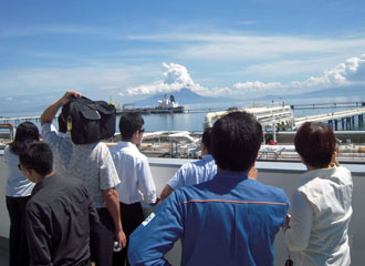 荷役中のタンカーと噴煙を上げる桜島