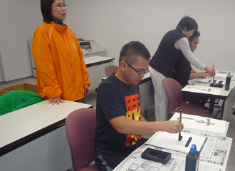 Harada sensei guides us in writing calligraphy